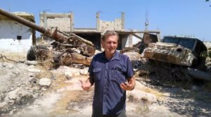 Gerhard Trabert 2019 im kurdischen Kobane vor Ruinen des Krieges. - Video: Trabert/Screenshot: gik