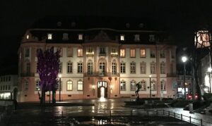 Der Schillerplatz bei Nacht mit bunt angestrahltem Fastnachtsbrunnen und Fassadenbeleuchtung. - Foto: gik 