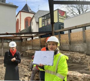 Landesarchäologin Stephanie Metz (in Gelb) präsentierte im März in der Baugrube am Bischofsplatz die ersten Grabungsergebnisse. – Foto: gik