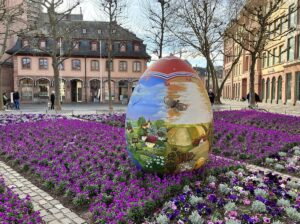 Eines der drei bunt bemalten kroatischen Ostereier im Blumenbeet auf dem Liebfrauenplatz. - Foto: gik