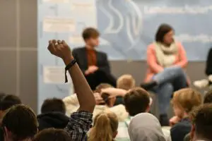 Vertreter der Landesschülervertretung Rheinland-Pfalz auf einem Podium mit Schülern im Vordergrund. - Foto: LSV RLP