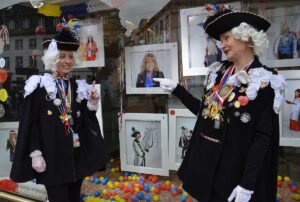 Anna Meffert (links) und Maria Weyand vor den Portraits von Frauen in der Fastnacht, in der Mitte: Petra Wagner-Behrendt. - Foto: gik