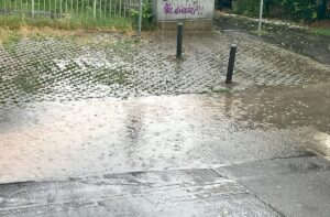 Überflutete Straße und Gehweg wegen verstopftem Gullideckels. - Foto: gik