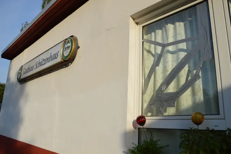 AfD Schützenhaus - Eingeschlagenes Fenster und weiße Wand