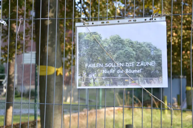Protestplakat an der Lesselallee: "Fallen sollen die Zäune, nicht die Bäume" - Foto: gik