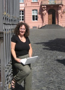 Journalistin Gisela Kirschstein mit weißem Laptop vor dem Mainzer Landtag am Platz der Republik