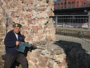 Der frühere Landesarchäologe Gerd Rupprecht beim Abreißen der Mauer am Römischen Theater. - Foto: gik