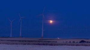 Der Beginn der partiellen Mondfinsternis über den Feldern von Klein-Winternheim mit Windrädern. - Foto: AAG