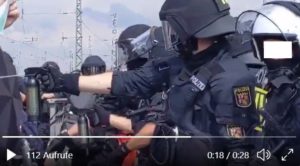 Einsatz von Pfefferspray eines Polizisten am Kreisel in Ingelheim gegen eingekesselte Demonstranten. - Video: Artemisclyde, Screenshot: gik