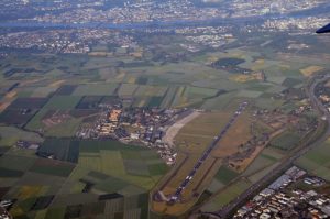 Luftaufnahme des Flugplatzes Wiesbaden-Erbenheim, oben der Rhein und Mainz. - Foto via Wikipedia von TA Düsseldorf
