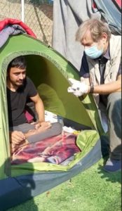 Trabert bei der Behandlung des behinderten Abdulkarims im Flüchtlingslager auf Lesbos. - Foto: Trabert