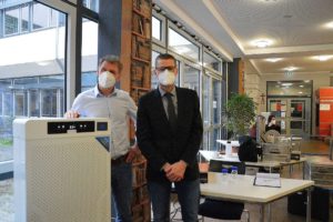 Matthias Baun (links) und Unfallchirurg Michal Oberst (rechts) mit einem Raumluftreiniger in der Willigis-Bibliothek.- - Foto: gik