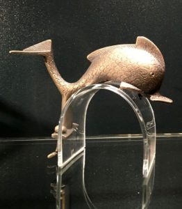 Schmuckstück aus Bronze: Ein fein verzierter und geschwungener Delphin, der einst wohl einen Reisewagen oder eine Truhe zierte. - Foto: gik