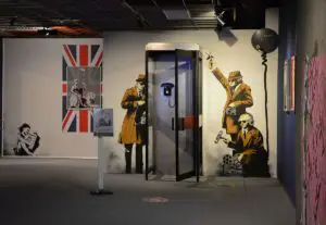 Berühmte Banksy-Szene rund um eine Telefonzelle, zu sehen in der Mainzer Ausstellung "The Mystery of Banksy". - Foto: gik