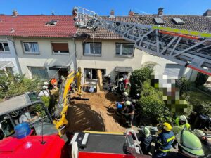 Die Baugrube hinter einem Reihenhaus in Mainz-Mombach, in der ein Mann verschüttet wurde. - Foto: Feuerwehr Mainz