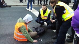 Polizisten im Gespräch mit einem der Aktivisten der Letzten Generation in Mainz. - Foto: Letzte Generation