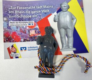 Das neue Zugplakettcher für die Fastnachtskampagne 2024 in Mainz bildet das Denkmal des Schoppestechers ab. - Foto: gik
