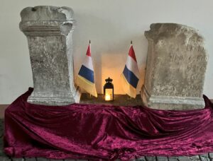 Die zwei Weihealtäre aus dem Mithras-Heiligtum in antiken Mogontiacum, geschmückt mit Fastnachtsfahnen. Der linke Altar ist der des Secundinius Amantius- Foto: gik