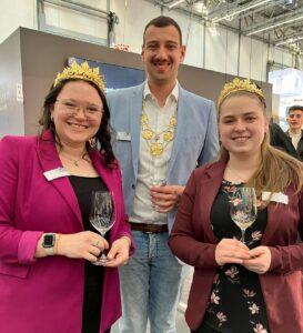 Das Weinmajestäten-Trio aus Rheinhessen 2024-2025: Der erste Weinkönig Levin McKenzie mit seinen Weinprinzessinnen Laura Schlösser (links) und Katja Klemmer. - Foto: gik