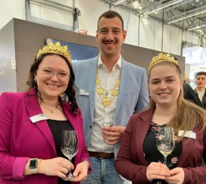 Das alte rheinhessische Weinmajestätentrio mit Levin I. McKenzie in der Mitte im März 2025 auf der ProWein in Düsseldorf. - Foto: gik