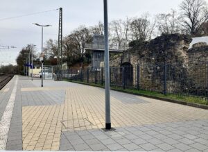 Der Verlauf des antiken Bühnentheaters und seiner großen Rückwand ist auf dem Boden des Bahnsteigs 4 im Bahnhof Römisches Theater markiert. Im Hintergrund der neue Aufzug vom Bahnhof hinauf zur Zitadelle. - Foto: gik