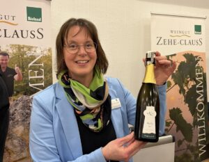 Die Mainzer Winzerin Birgit Zehe-Clauss mit einer Flasche ihres ausgezeichneten Riesling Sekts brut 2022. - Foto: gik