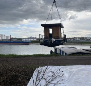 Boot am Kranen-Haken: Hier schwebt das geborgene Wrack auf eine Abstellfläche am Ufer des Industriehafens. - Foto: Polizei Mainz