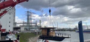 Das gesunkene Boot musste letztlich mit Hilfe eines Krans geborgen werden, hier hängt es vor der Kulisse des Mainzer Industriehafens. - Foto: Polizei Mainz