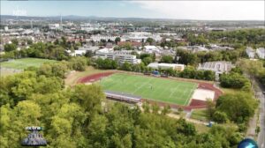 Luftaufnahme des Fußballstadions des TSV Schott in der NDR-Sendung Extra3 - die Photovoltaikanlage ohne Anschluss ist unten im Bild zu sehen. - Screenshot;: gik